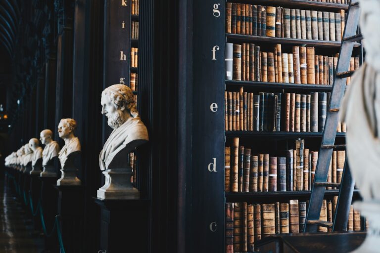 Biblioteca antiga com bustos de mármore e estantes de livros
